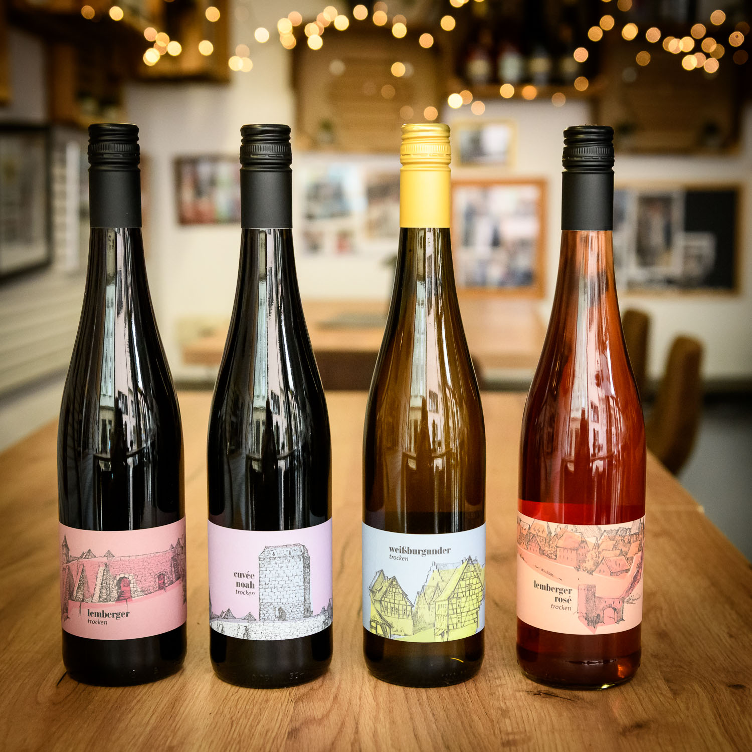 4 verschiedene Weinflaschen stehen auf einem Tisch im Vinosseum